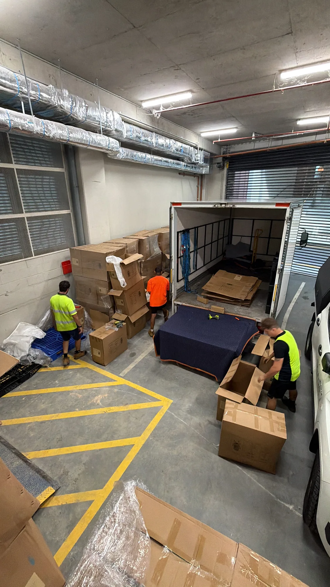 LOG Transport crew loading office boxes and wrapped furniture at a loading dock