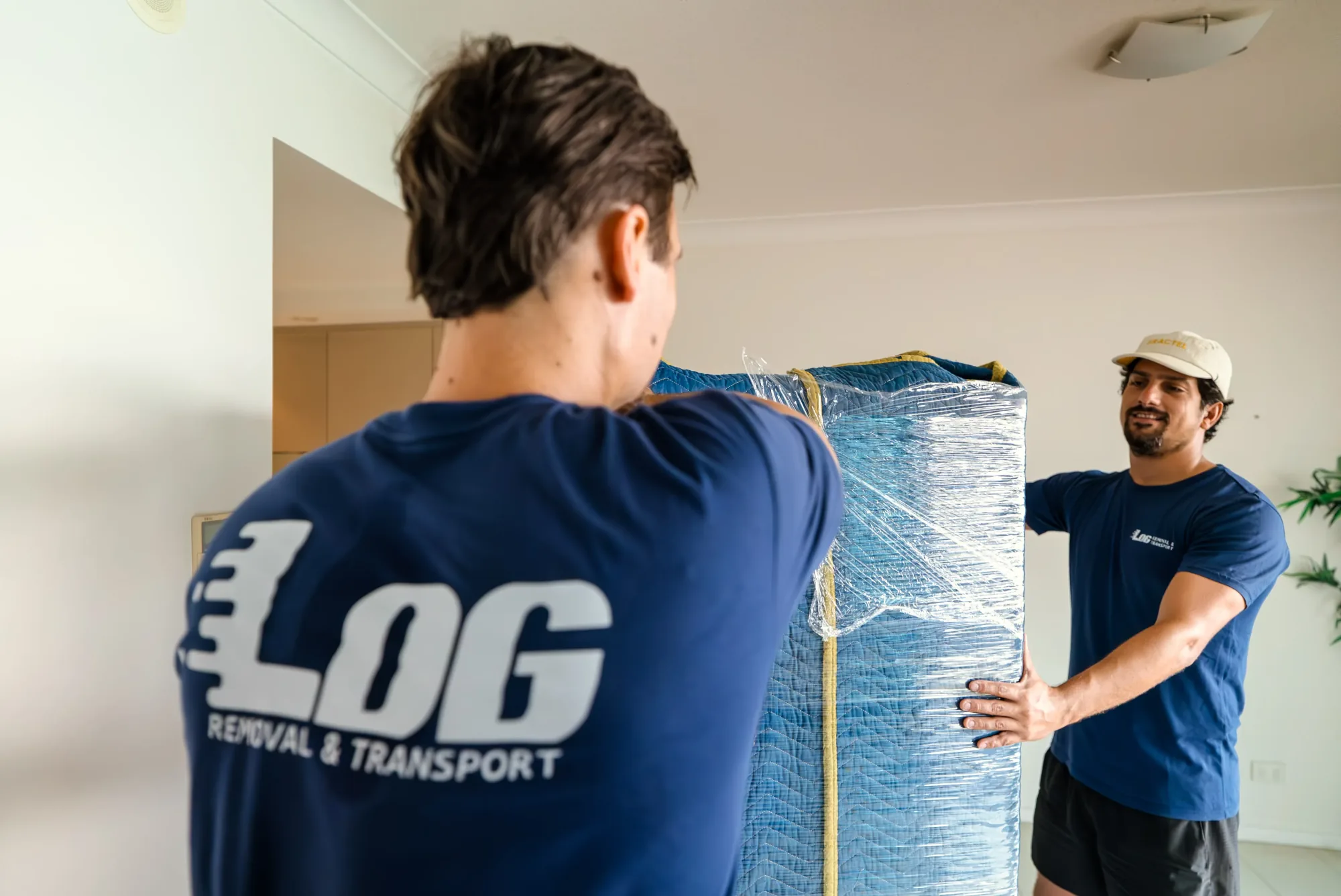 LOG Transport team carrying a wrapped piece of furniture together