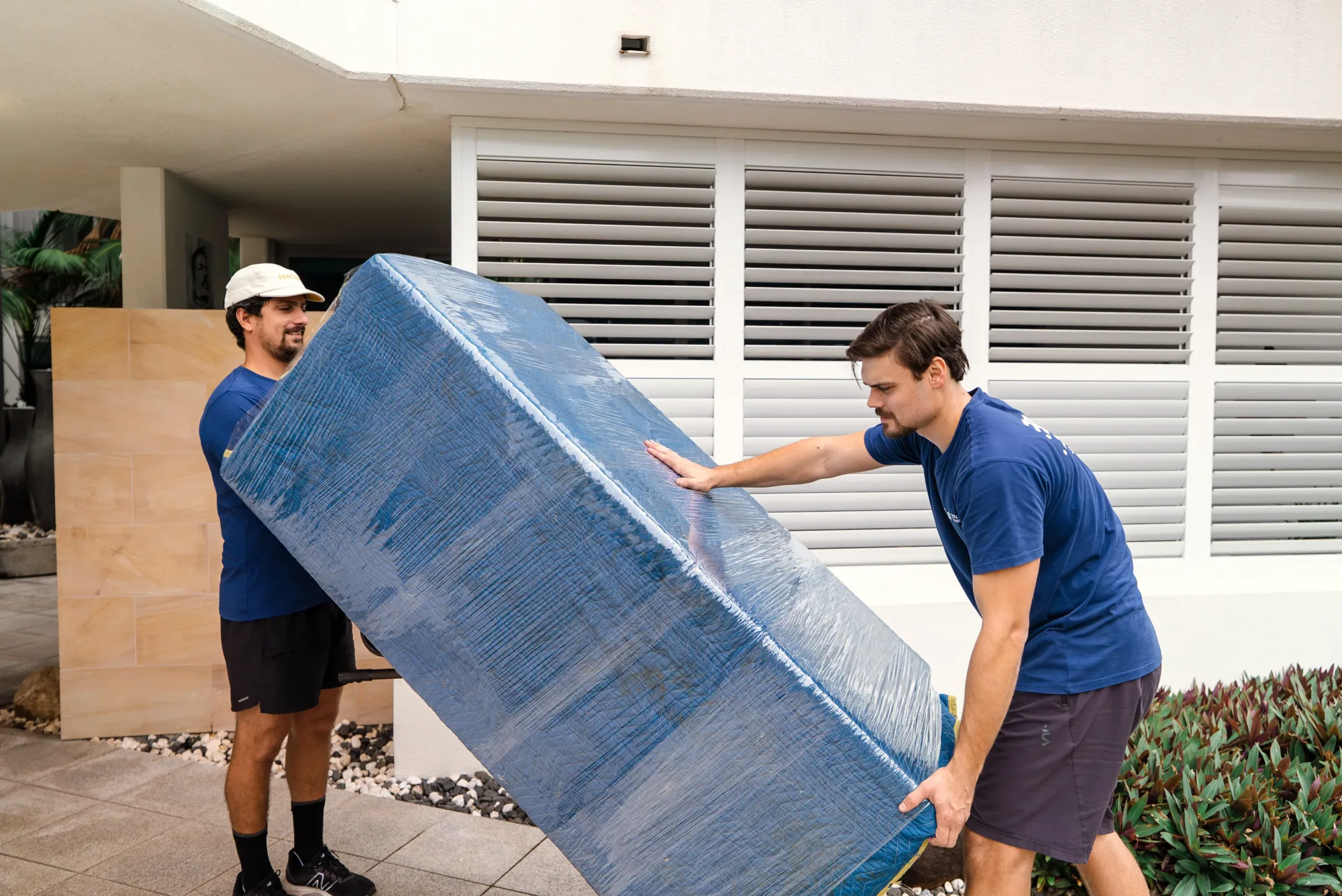 LOG Transport team carefully wrapping and stacking furniture for a Broadbeach apartment move