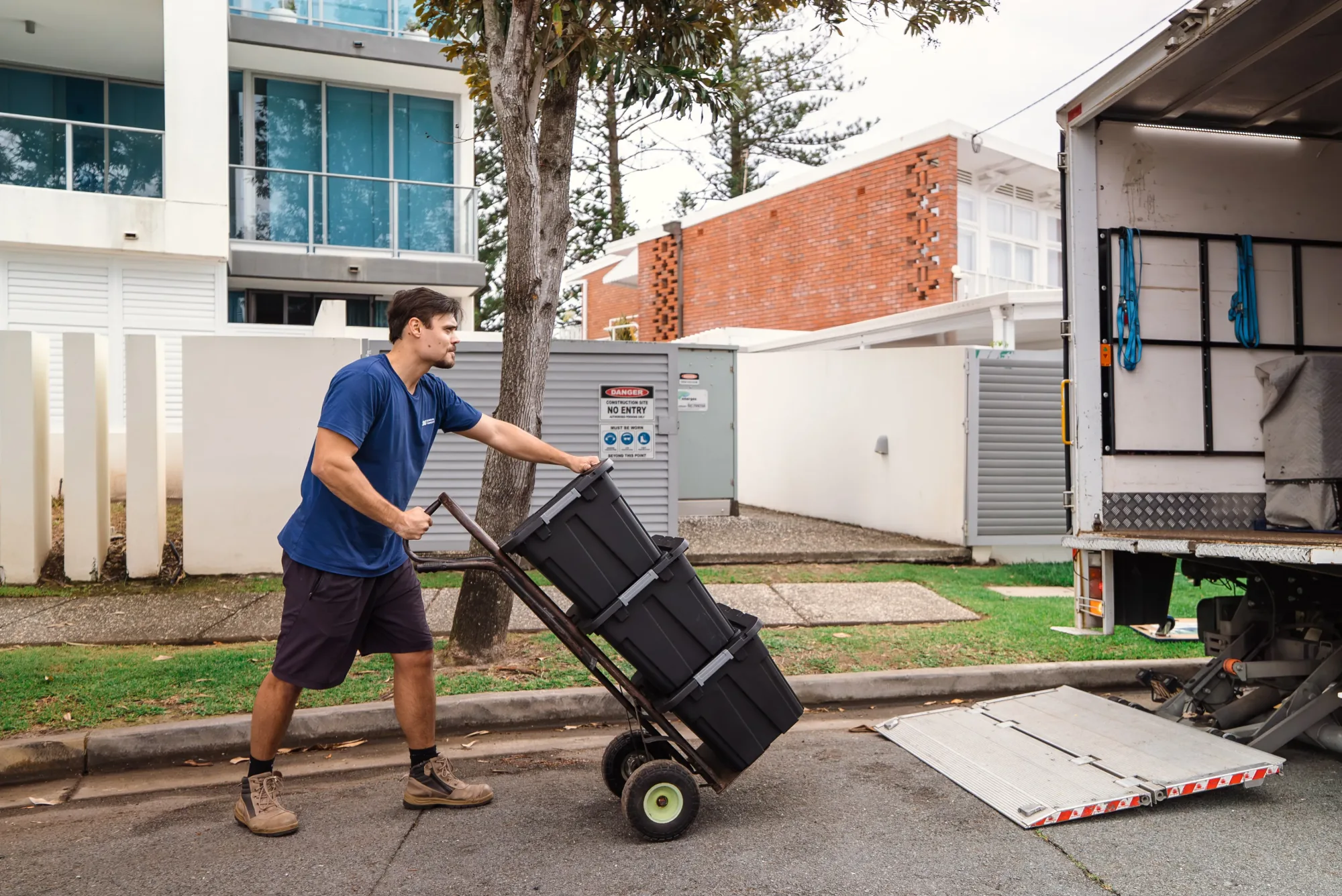 LOG Transport team wheeling stacked moving tubs out of a Robina family home